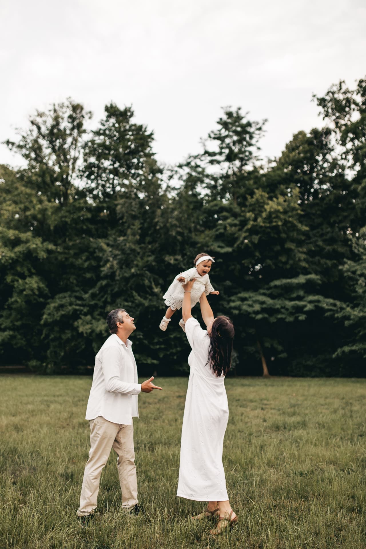 Parents lifting their baby during a family day outdoors